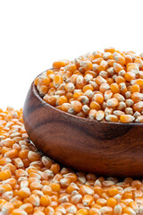 Dried corn kernels in wooden bowl isolated on white
