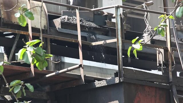 A video of pressed charcoal or bituminous coal falling into the hoppers or funnels