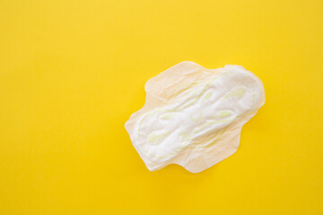 Women's sanitary napkin on a yellow background close-up.