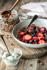 A healthy breakfast bowl with granola clusters and berries with greek yogurt.