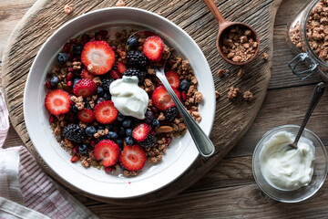 Above view of a healthy breakfast bowl containing berries, granola and yogurt.