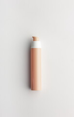 Cosmetic beige tube from above overhead top view on white background, blank mockup for your branding or packaging design, natural beauty product concept, vertical
