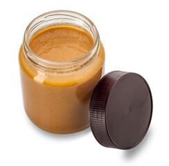 Peanut butter in an open glass jar top view with the cap close beside