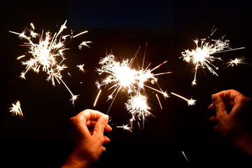 Hands holding a sparkler at night