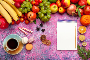top view fresh fruit composition colorful fruits with cup of tea and french macaronson the light-pink background fruit fresh mellow color ripe