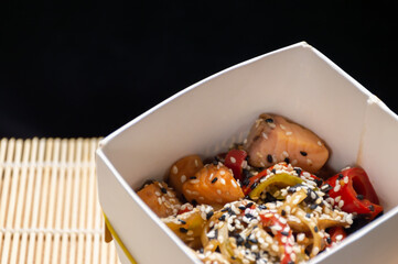 Chinese noodles with salmon, vegetables and sesame seeds