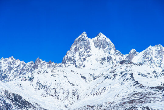 Beautiful panoramic view Ushba peak in Caucasus mountains covered with snow in winter and blue sky in Mestia Svaneti Georgia