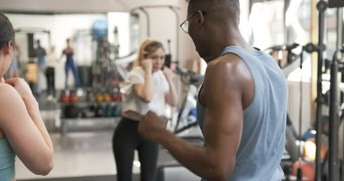 Rear view of a coach teaching boxing in a gym