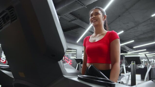 Young asisn woman workout with walking and exercise on machine treadmill in fitness gym sport club, woman cardio with training jogging, healthcare and motivation, female in sportswear and health.