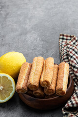 Homemade lemon jam filled sticks in wooden bowl on gray background