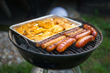 Summer barbecue in the garden. Shot on a hot grill with meat and sausages.