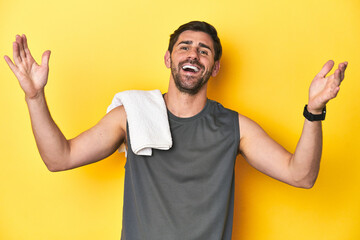 Sporty Caucasian man with towel, studio shot on yellow Sporty Caucasian man with towel, studio shot...