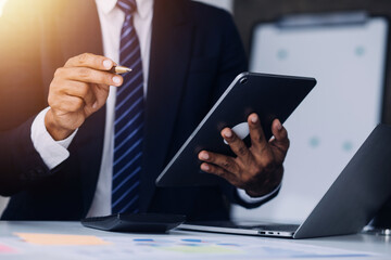 Financial analysts analyze business financial reports on a digital tablet planning investment project during a discussion at a meeting of corporate showing the results of their successful teamwork.