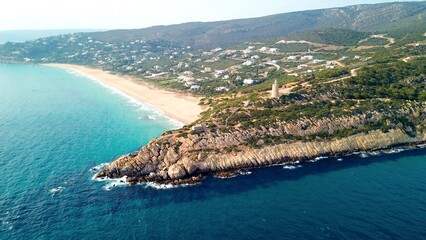 Faro de Camarinal, aerial view of the lighthouse on a cliff at the the wonderful sandy beach with the blue turquoise Atlantic Ocean, Playa Los Alemanes, Andalusia, Spain © keBu.Medien