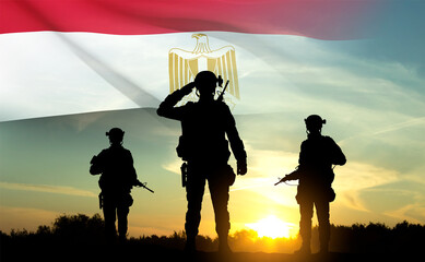 Silhouettes of soldiers against the sunset with Egypt flag. Background for National Holidays. Concept - Armed Forces