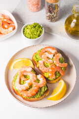 Shrimps on toast with avocado and lemon. Breakfast concept. Bruschetta. 