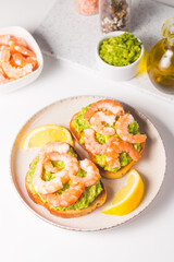 Shrimps on toast with avocado and lemon. Breakfast concept. Bruschetta. 