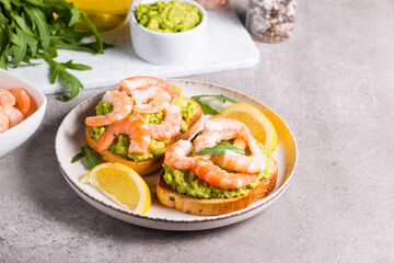 Shrimps on toast with avocado and lemon. Breakfast concept. Bruschetta. 