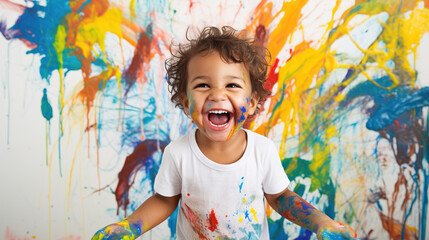 Obraz na płótnie Canvas A happy child playing with paints and showing their creativity