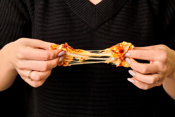 Female hands breaking savory baked bread roll with cheese