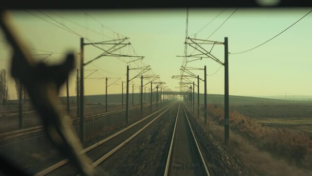 4K footage from train moving on railway in sepia tinted daylight against Mexican rural background. Railway tracks seen from locomotive driver perspective POV stock video.	