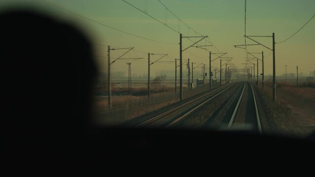 4K action cam footage from moving train on railway in sepia tinted daylight against Mexican rural background. Railway tracks seen from locomotive driver perspective POV stock video.
