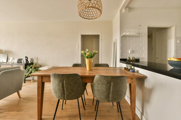 a dining room with chairs and a table in front of the couchs that are facing towards the kitchen...