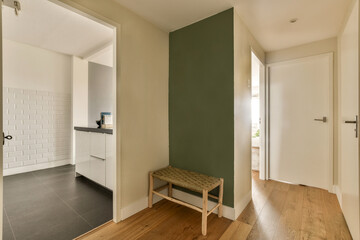 an empty room with a bench in the middle and a door leading to another room on the other side,