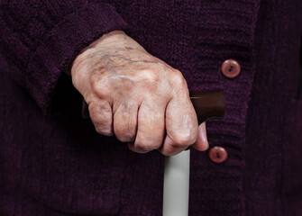 Hand of an elderly woman on a cane