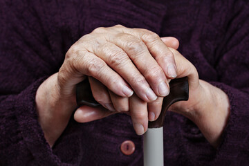 Hands of an elderly woman on a cane