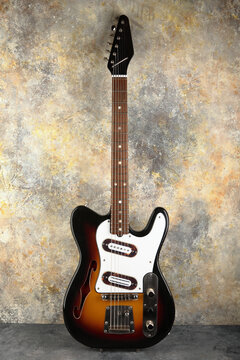 Vintage electric guitar telecaster's form on plastered background.
