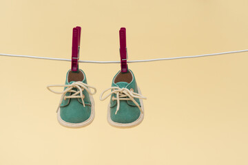 Childrens shoes are drying on a rope. Childhood concept