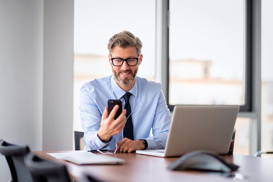 Executive businessman sitting at the office and using smartphone and lapto for work