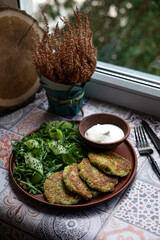 Zucchini pancakes with arugula and cucumbers