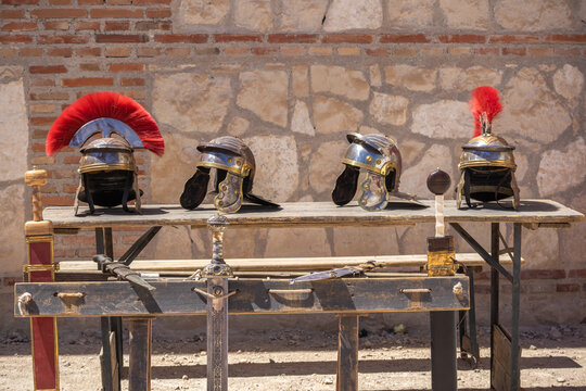outdoor display of soldier helmets and swords from the ancient roman empire