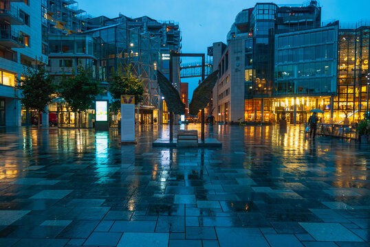Illuminated Akker Brygge, a modern district in Oslo city center at night and in the rain, Norway
