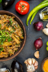 Above view of delicious dinner with eggplant dish fresh vegetables green bundle pepper fallen oil bottle on black table