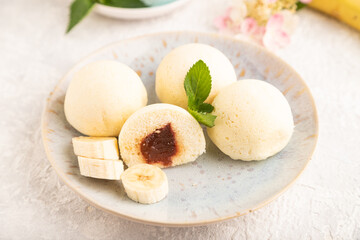 Japanese rice sweet buns mochi filled with jam on a gray concrete. side view, selective focus.