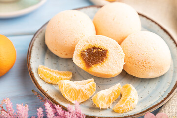 Japanese rice sweet buns mochi filled with tangerine jam on a blue wooden. side view, selective focus.