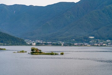 Shrine sitting on island in the middle of a mountain lake in the Japanese mountains