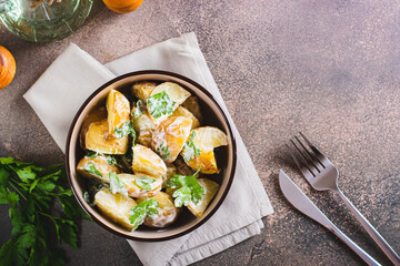 Potato salad in a peel with parsley and mayonnaise in a bowl on the table top view