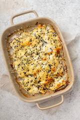White fish casserole with cheese, sour cream and onion
