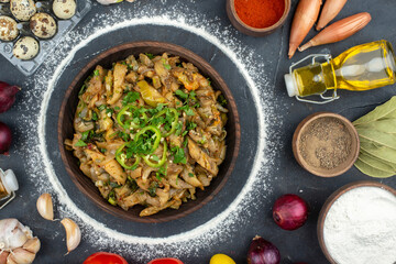 Close up view of delicious meal among fallen oil bottle eggs fresh vegetables flour spices on black background