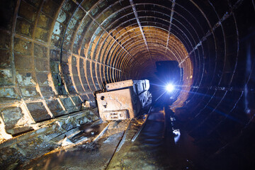 Old abandoned subway tunnel with rusty trolley locomotive