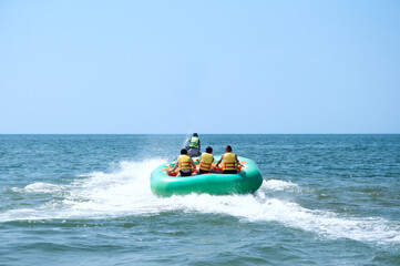 Fototapeta premium Walk on an inflatable mattress at ocean on a tow of a water motorcycle