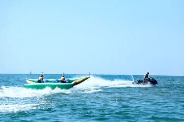 Fototapeta premium Walk on an inflatable mattress at ocean on a tow of a water motorcycle
