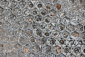 Plastic and gravel hardstanding over grass with hexagonal design - image