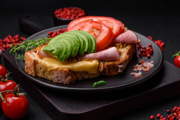 Delicious nutritious grilled toast with ham, cheese, tomatoes and avocado