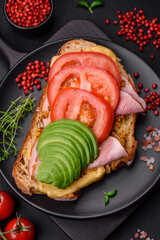 Delicious nutritious grilled toast with ham, cheese, tomatoes and avocado
