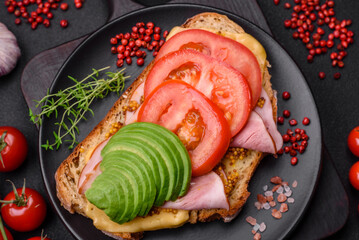 Delicious nutritious grilled toast with ham, cheese, tomatoes and avocado